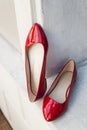 Leather red women& x27;s shoes on a white wooden shelf. Fashion, minimal fashion concept, women& x27;s shoes, accessories. red