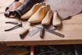 Leather in rolls, cobbler tools and shoe lasts in workshop. Leather craft tools.