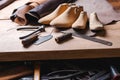 Leather in rolls, cobbler tools and shoe lasts in workshop. Leather craft tools. Royalty Free Stock Photo