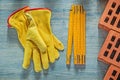 Leather safety gloves red bricks wooden meter on wood board bric Royalty Free Stock Photo