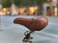 Leather seat of a bicycle worn out in brown color in a public wa