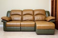 Leather sectional reclining sofa in family room in earthy green and brown tones