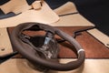 Leather steering wheel brown color in the process of stitching with a bright contrast seam and white central point on the top in