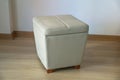 Leather tabouret stool in the room with a wooden floor