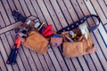 Leather tool belt with construction tooling on the wooden board. Maintenance concept Royalty Free Stock Photo