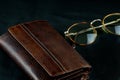 Leather Wallet and Old Spectacles on a Black Table Cloth Royalty Free Stock Photo