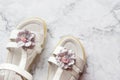 leather white baby girl summer sandals with flower decoration.Baby girl shoes on marble background. kids fashion pair Royalty Free Stock Photo