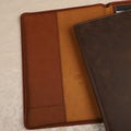 Leather Zipper Portfolio. Concept shot, top view, flap portfolio in brown colors and leather pen. Custom background flap portfolio Royalty Free Stock Photo