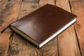 leatherbound notepad on varnished oak plank