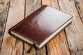 leatherbound notepad on varnished oak plank