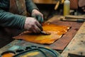 leatherworker dyeing a piece of leather on a workbench Royalty Free Stock Photo