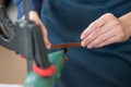 Leatherworker grinding the edge of a strip of leather for a belt in the workshop. Royalty Free Stock Photo
