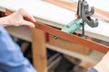 Leatherworker grinding the edge of a strip of leather for a belt in the workshop. Royalty Free Stock Photo