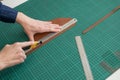 Leatherworker measuring and cutting leather in workshop. Royalty Free Stock Photo