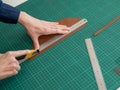 Leatherworker measuring and cutting leather in workshop. Royalty Free Stock Photo