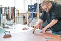 Leatherworker measuring and cutting leather in workshop. Royalty Free Stock Photo