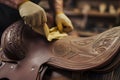 leatherworker smoothing a saddle with a cloth Royalty Free Stock Photo