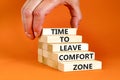 Leave comfort zone symbol. Concept words Time to leave comfort zone on wooden blocks. Businessman hand. Beautiful orange