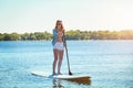 Leave your worries on the land. an attractive young woman paddle boarding on a lake.