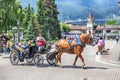 LEAVENWORTH, WA, USA, JUNE 25, 2023: A horse carriage for hire with tourists in the colorful Bavarian themed village of