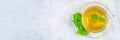 Leaves of fresh green nettle and a clear glass cup of herbal nettle tea on a gray concrete table. Top view. Royalty Free Stock Photo