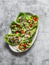 Leaves of mini roman salad stuffed with tuna, egg, tomato, avocado on a gray background, top view. Delicious appetizer, tapas, Royalty Free Stock Photo