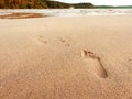 Leaving footprint on the sand. Close-up footprint from foot step walking on the sandy beach on sea and rock island view.