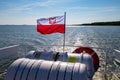 Leba, pomorskie / Polska ÃÂ¢Ã¢âÂ¬Ã¢â¬Å 14 lipca 2019 :Polish flag suspended on the stern of a small inland ship. A vessel floating on a Royalty Free Stock Photo