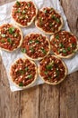 Lebanese Arab pizza with meat, tomatoes, spices and pine nuts closeup. Vertical top view Royalty Free Stock Photo