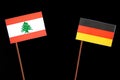 Lebanese flag with German flag isolated on black Royalty Free Stock Photo