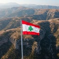A Lebanese flag waves prominently against a backdrop of rugged mountains and Royalty Free Stock Photo