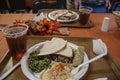 Lebanese food served on a plastic plate and tray - tabbouleh and hummus and rice and cabbage roll - shallow focus