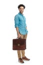 lebanese man holding suitcase and smiling while standing with hand in pocket Royalty Free Stock Photo