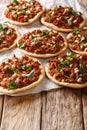 Lebanese Sfeeha meet pie or Lahm bi ajeen with ground beef, onions, tomato, and pine nuts closeup. vertical Royalty Free Stock Photo