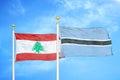 Lebanon and Botswana two flags on flagpoles and blue cloudy sky