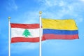 Lebanon and Colombia two flags on flagpoles and blue cloudy sky