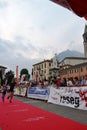 Sportsman arriving at the finish of `Lecco city - Resegone mountain` running marathon event.