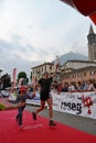 Sportsman arriving at the finish of `Lecco city - Resegone mountain` running marathon event.