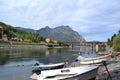 Adda river flowing from the lake Como, fishers and motorboats anchored at a shore.