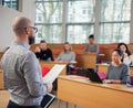 Lecturer and multinational group of students in an auditorium