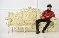 Lecturer sit on sofa and reading book, white wall background. Elite leisure concept. Man with beard and mustache spends