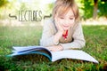 Lectures against cute little boy reading in park