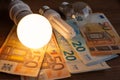 Led bulb on, incandescent bulb, fluorescent bulb, and money Royalty Free Stock Photo