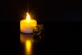 Led candle light with sparkly reflection and green marble balls on black background