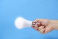 LED eco friendly light bulb in hand on blue background Royalty Free Stock Photo