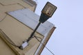 LED fixed on to a bend lamp post in front of a building. The lamp post is clamped on the pink wall with the wires roped around the Royalty Free Stock Photo