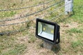 LED flood light on ground post with metal string fence background Royalty Free Stock Photo