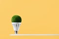 LED green grass light bulb yellow background. Green energy Royalty Free Stock Photo