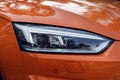 LED headlight. Close-up headlights of a modern orange color car. Detail on the front light of a car Royalty Free Stock Photo