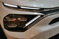 LED headlights and fog lights on modern french battery electric compact crossover SUV car Citroen e-C4 X.